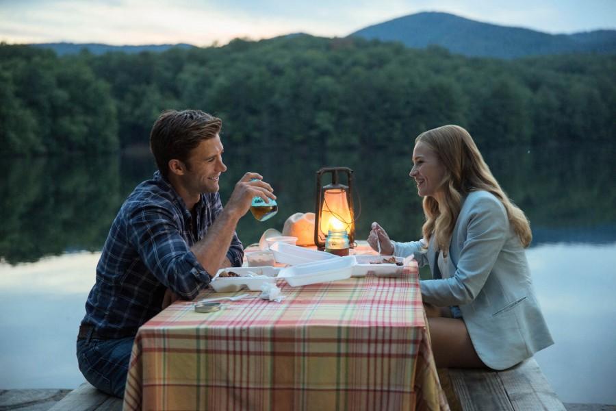 Luke (Scott Eastwood) and Sophia (Britt Robertson) dine together by the lake. 