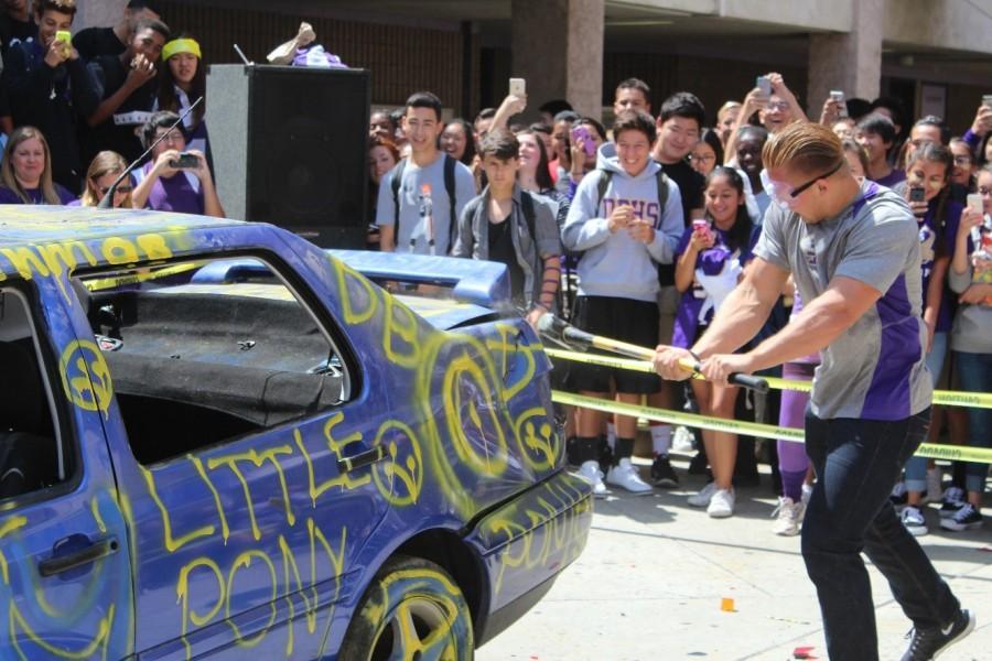 Senior Blake Goodman swings at a car during a lunchtime activity the week before the annual Branding Iron game against Walnut High School, which DBHS won for the fifth year in a row, 57-7.