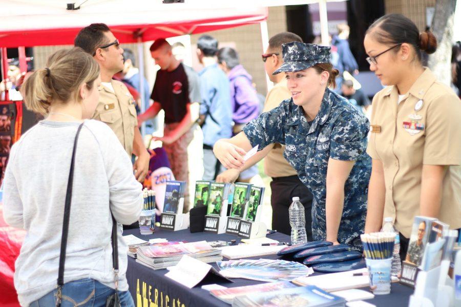 A member of the U.S. Navy explains her career to an interested student as part of the Career Fair, which took place on March 24 and featured a wide variety of professionals from different occupations.