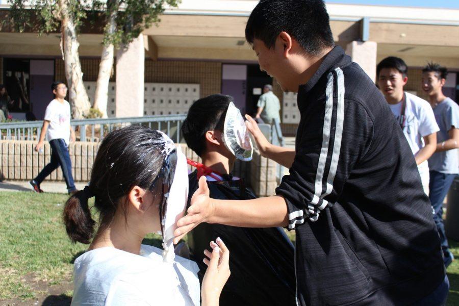 Alumnus Shawn Chae smashes pies in the faces of seniors Melanie Ho and Casey Chen in the event hosted by Red Cross.