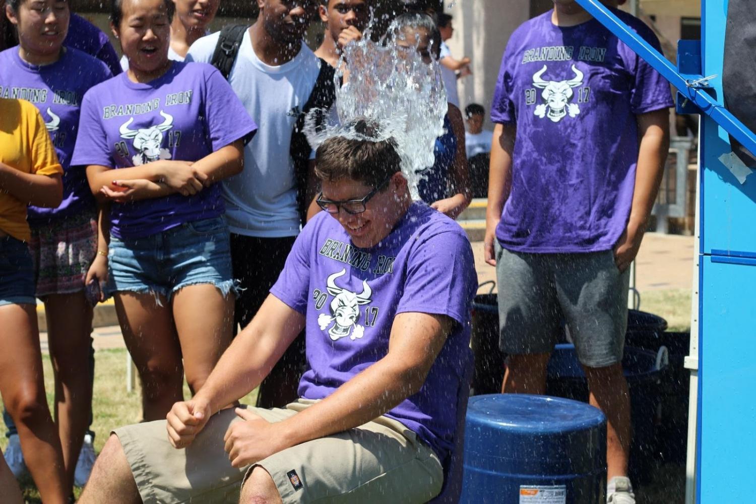Senior Matthew Rodriguez is dunked with water while participating in Branding Iron activities at lunch in the upper quad.