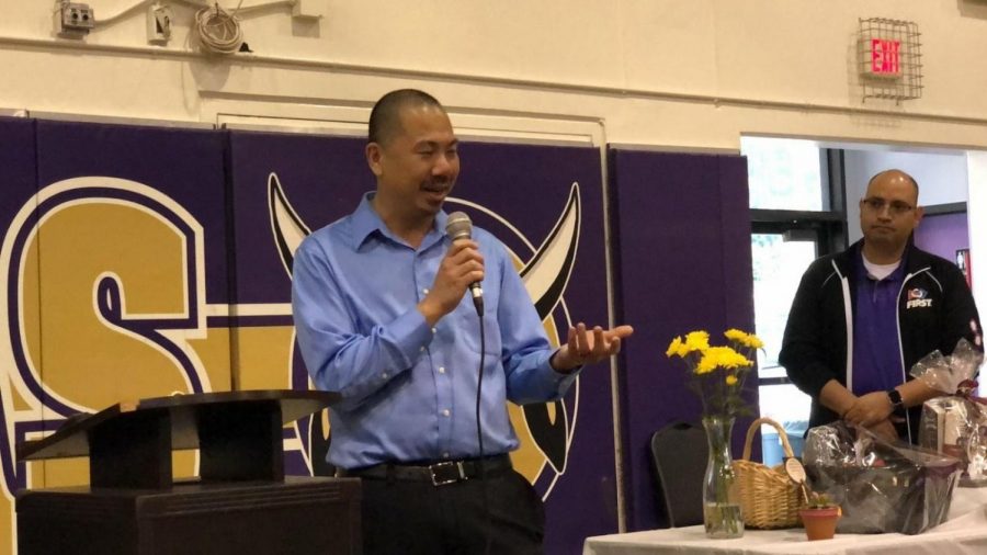 Johnny Hwang acknowledges his award in a speech at a staff luncheon.