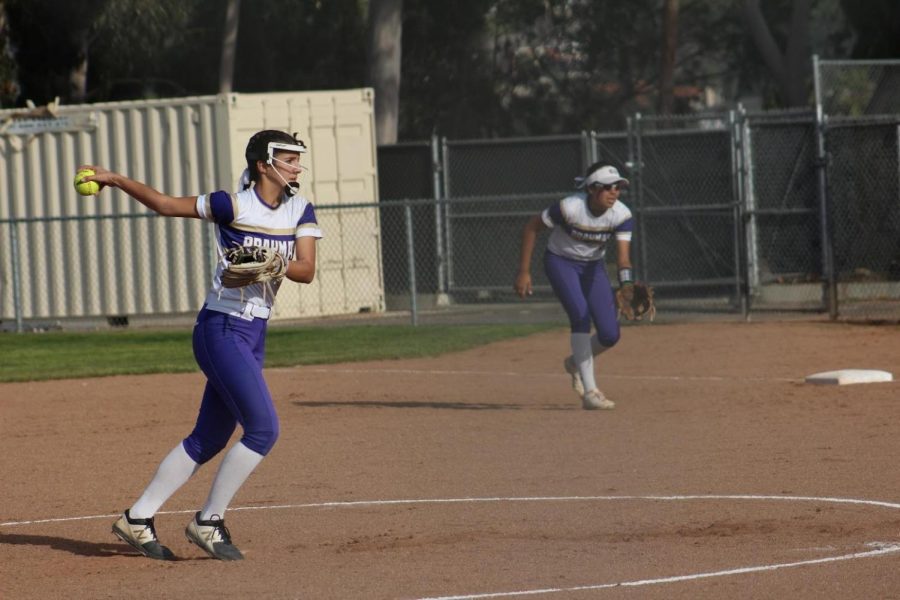 Sophomores Miranda Montes pitches while Carina Sanchez scans the outfield.