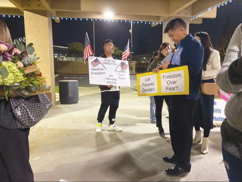 Walnut Valley Unified School District protestors stand with paper signs outside of the main WVUSD office, hoping to gain the attention of board members with their messages of “medical freedom” and anti-COVID vaccination mandate sentiments.