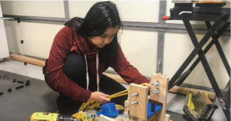 Sophomore Angel Huang and senior Darren Fang work to modify their ping-pong catapult used during the Engineering event.
